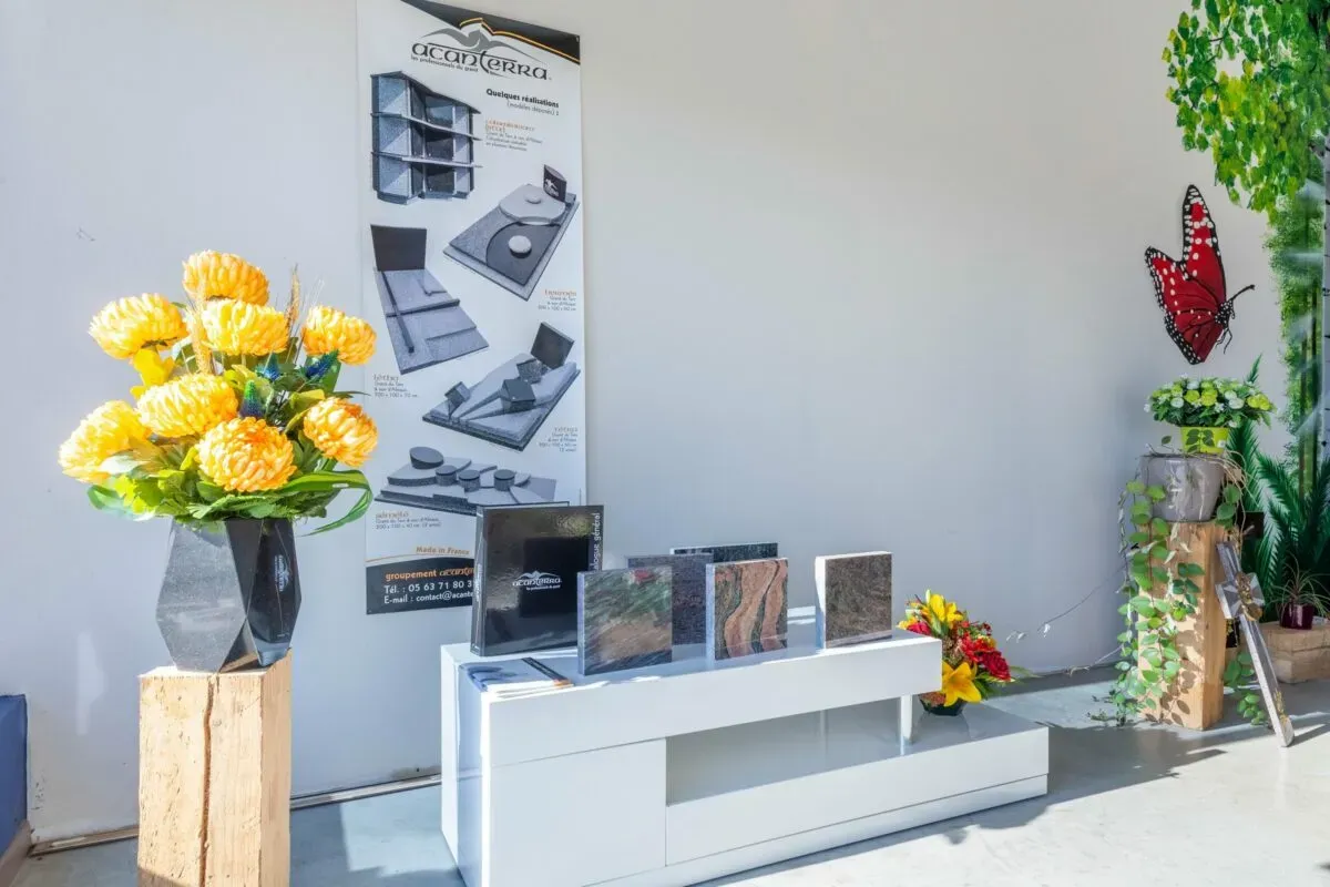 Présentation d'échantillons de granit funéraire et bouquets de fleurs.