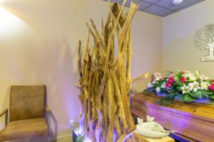 cercueil derriere un sculpture en bois